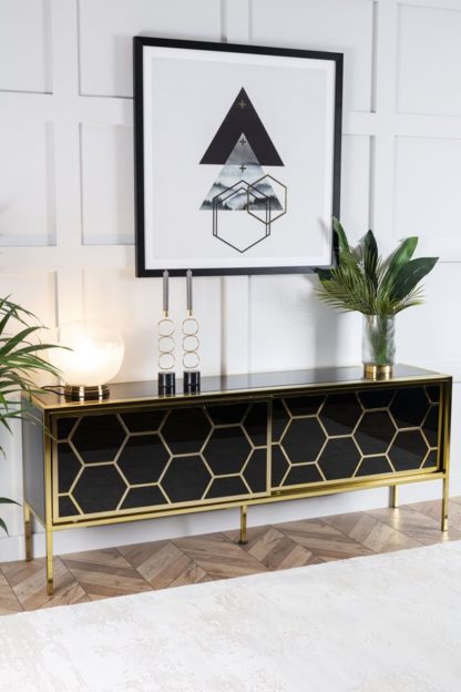 270227784c910e4ca68e1f8813e3c0911c736ad6e899a2a3c59ae5792c687250.jpg An Image of Alveare Brass and Black Glass Sideboard