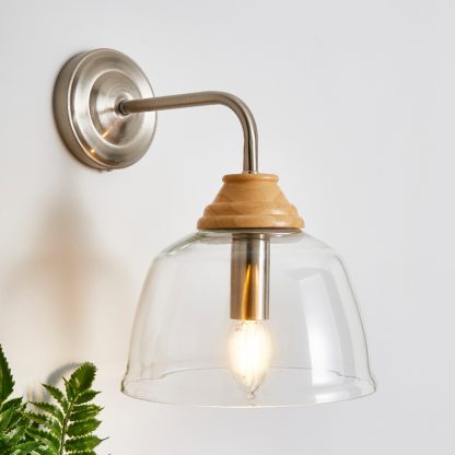 b8a243ce02857fabd68548857602ddece7fb907841d45276679a4faf5872b30e.jpg An Image of Churchgate Croxton Wood Glass Wall Light Satin Nickel